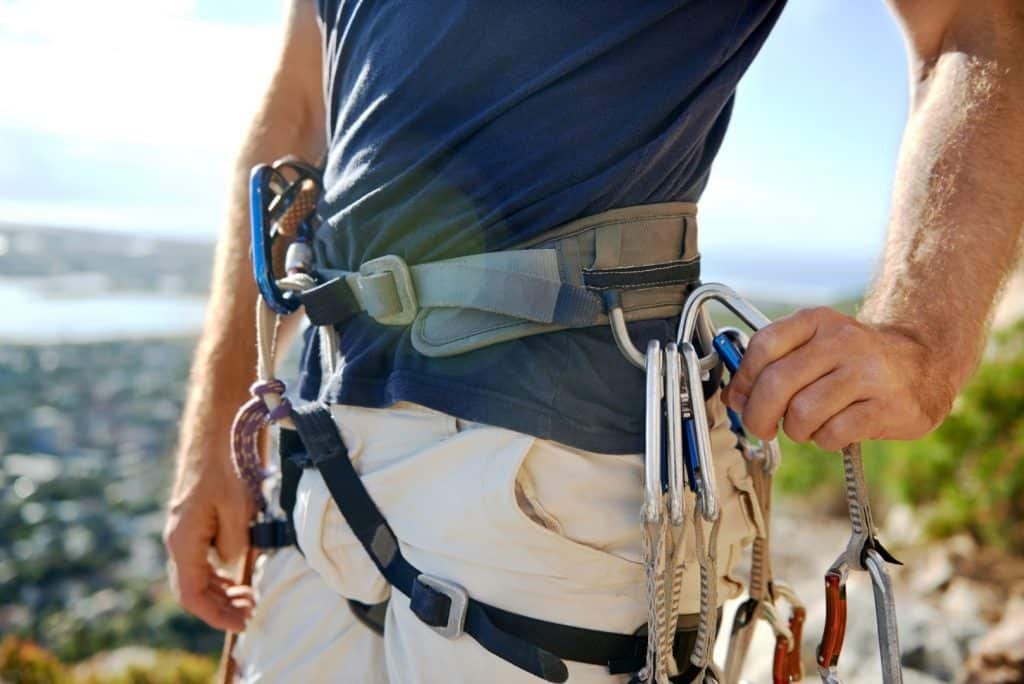Man with climbing harness and rock climbing equipment
