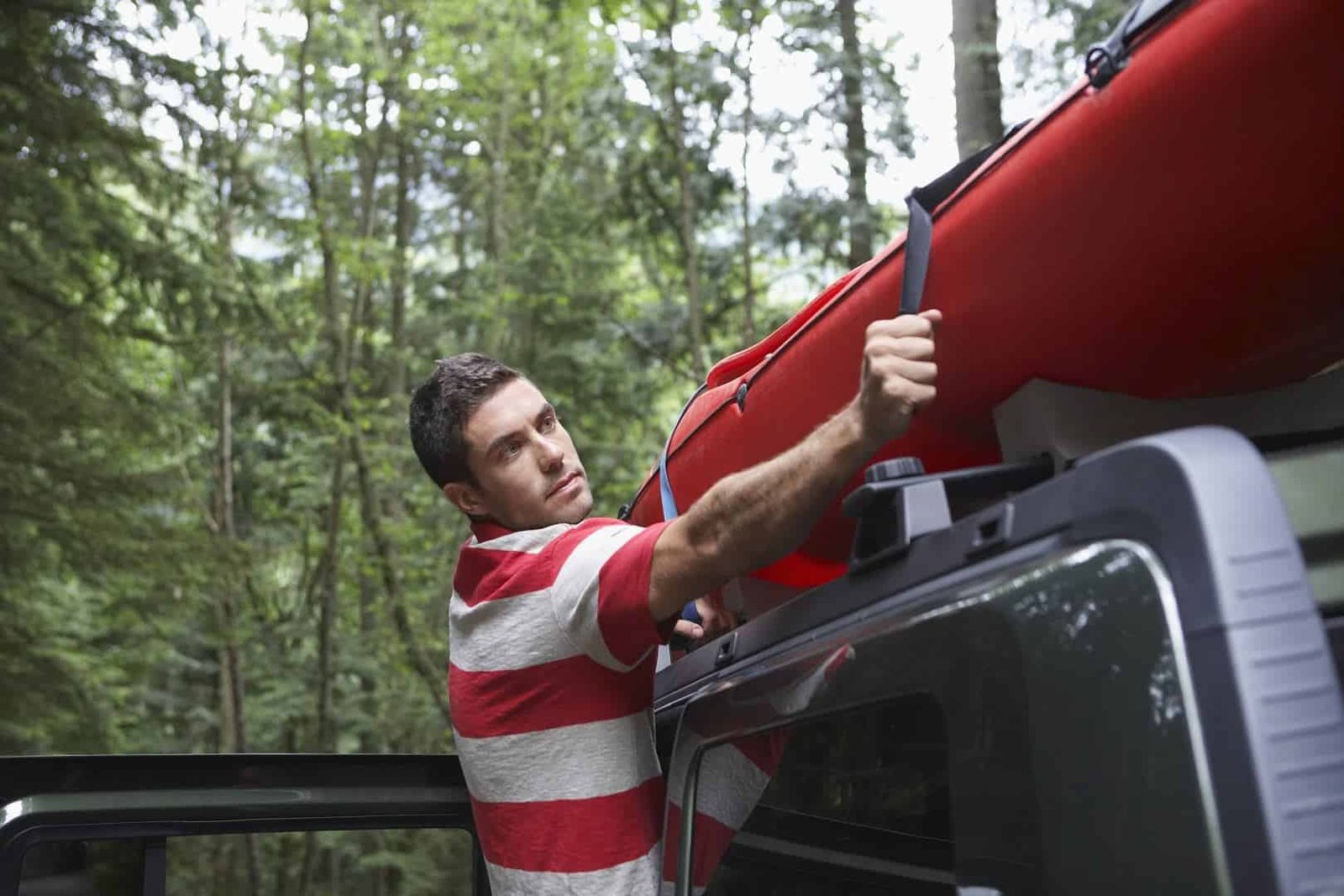 Man mounting a kayak without a roof rack